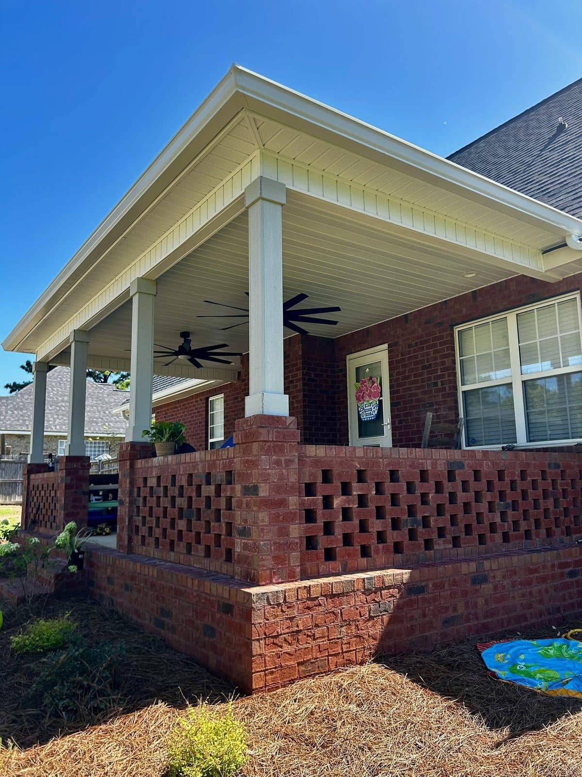 Finished covered back patio with brick lattice columns — outdoor construction project by Chaney Construction